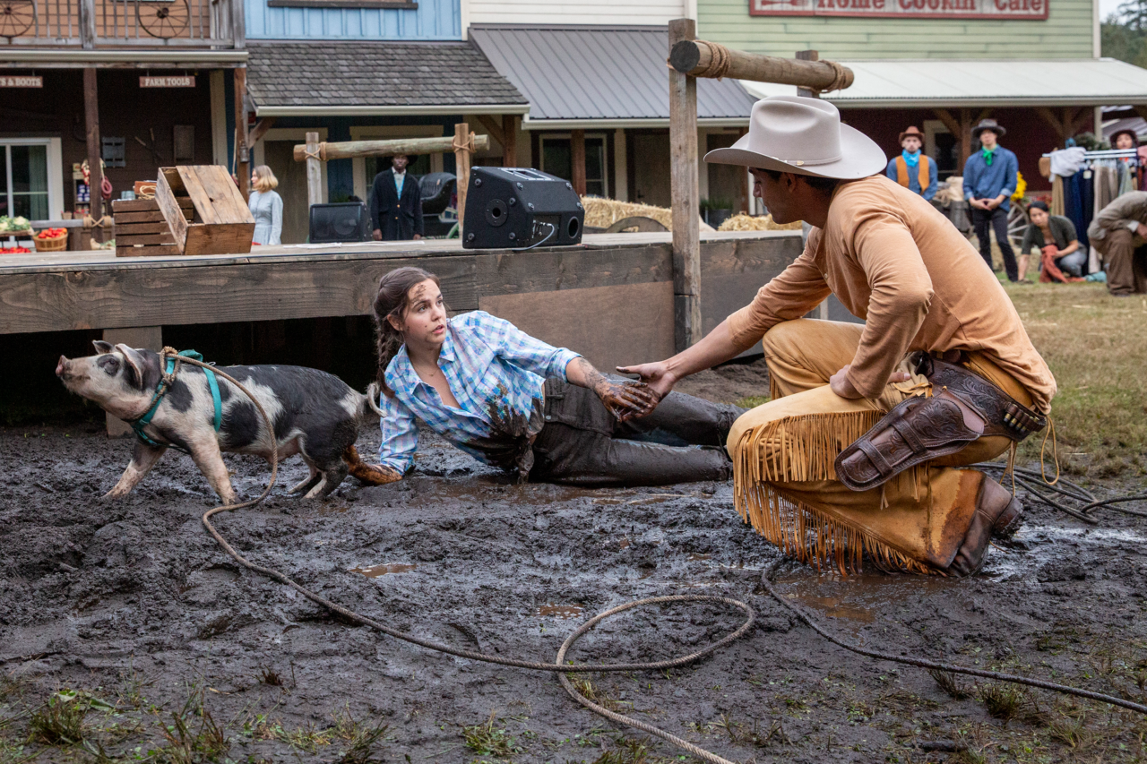 Finley Tremain (played by Bailee Madison) ends up in the mud, after her pig wreaks havoc on the Hollywood film set, and Jackson Stone (played by Michael Evans Behling) helps her up.